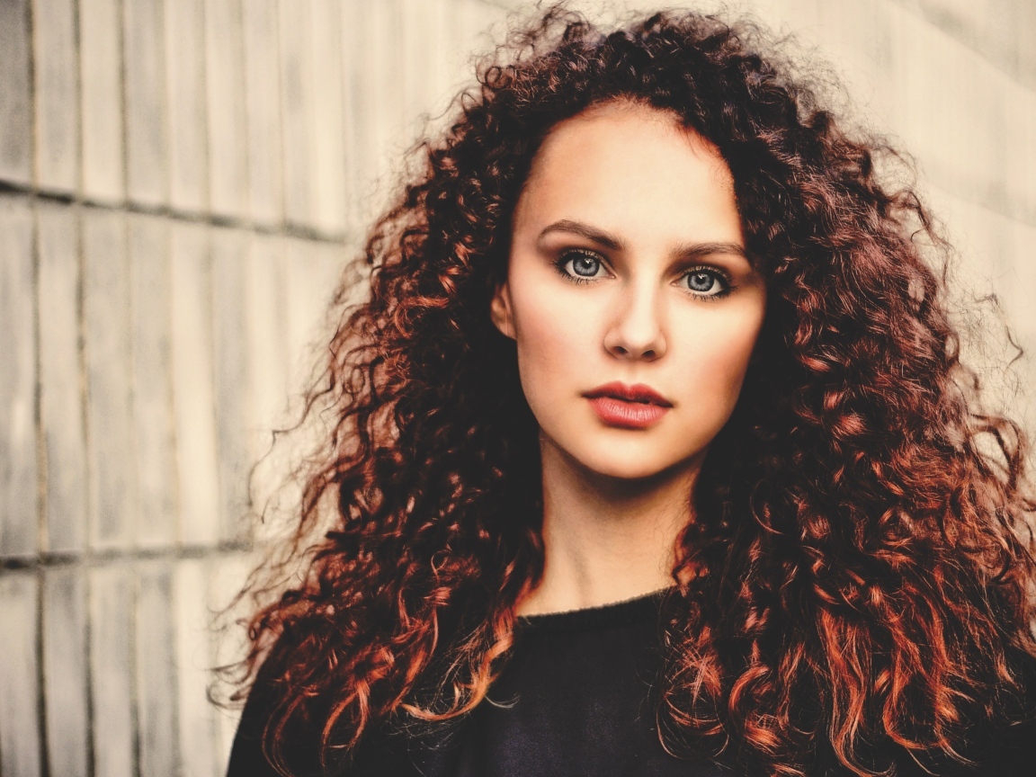 Кудрявые красивые волосы у девушки с серыми глазами
