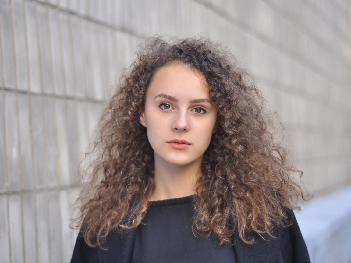Кудрявые волосы красивой кареглазой девушки 