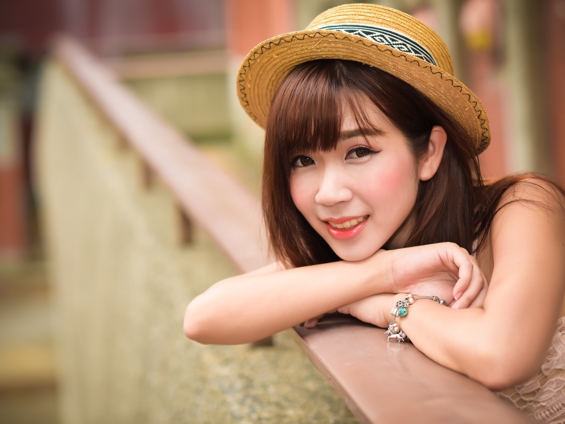 Милая улыбка азиатки в соломенной шляпе 