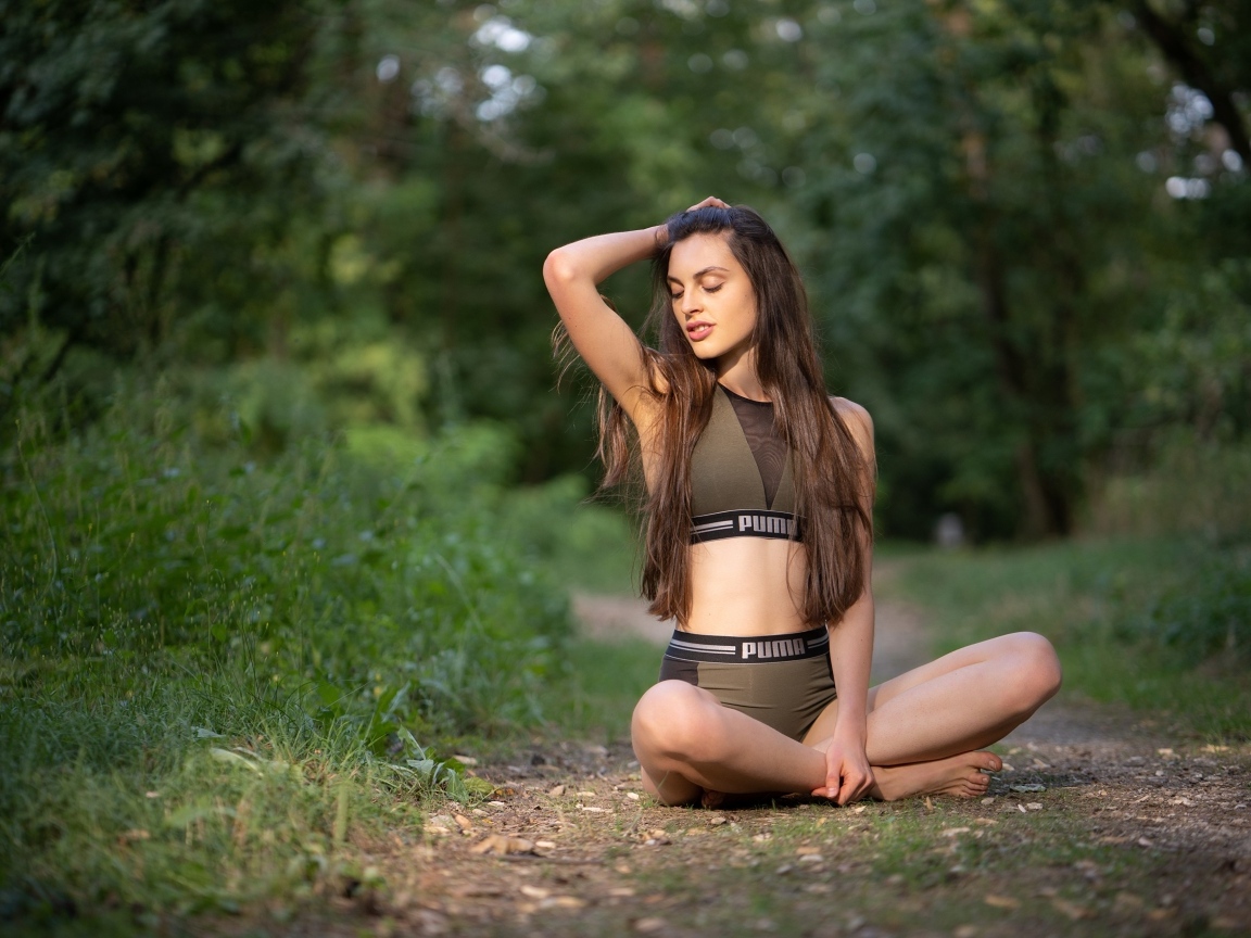 Девушка сидит в позе лотоса в осеннем парке