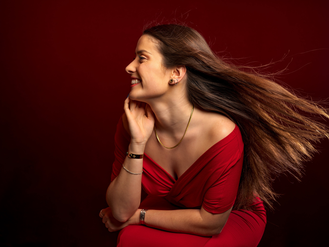 Длинные волосы у красивой девушки в красном платье