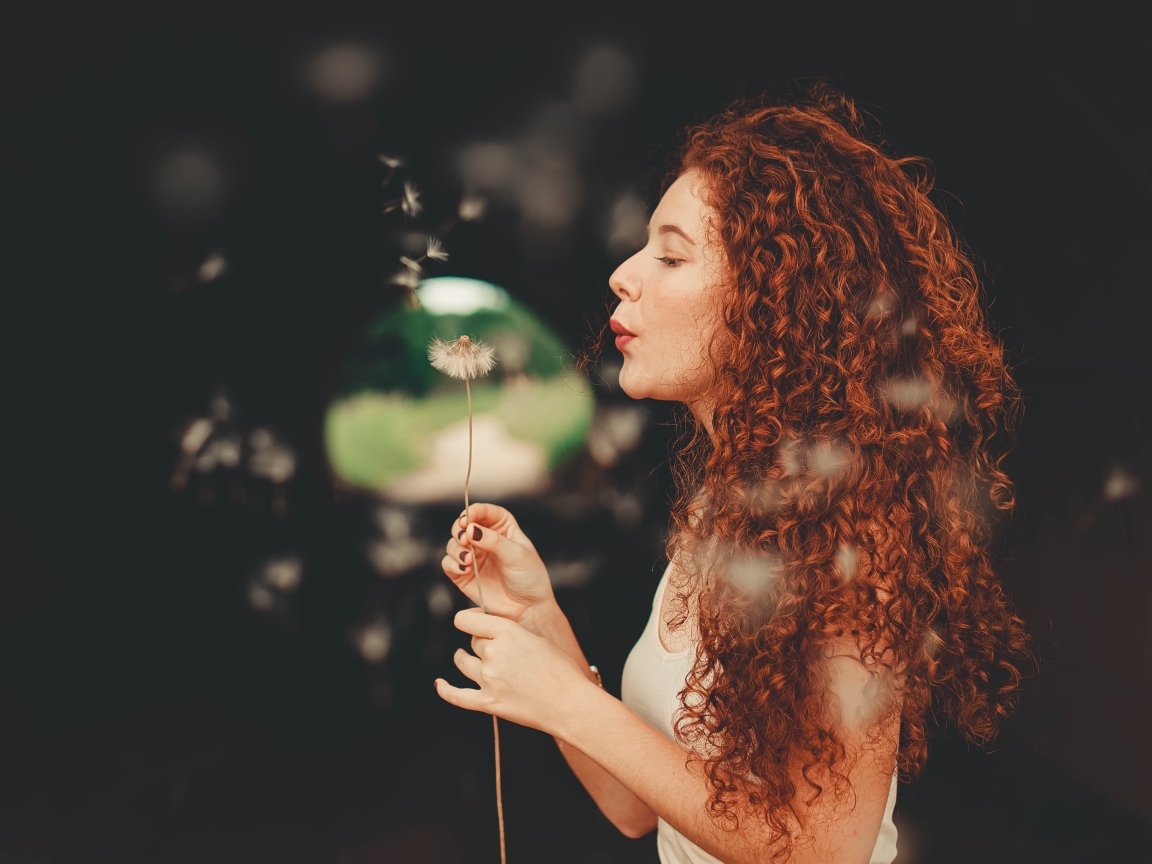 Рыжеволосая девушка с одуванчиком в руке