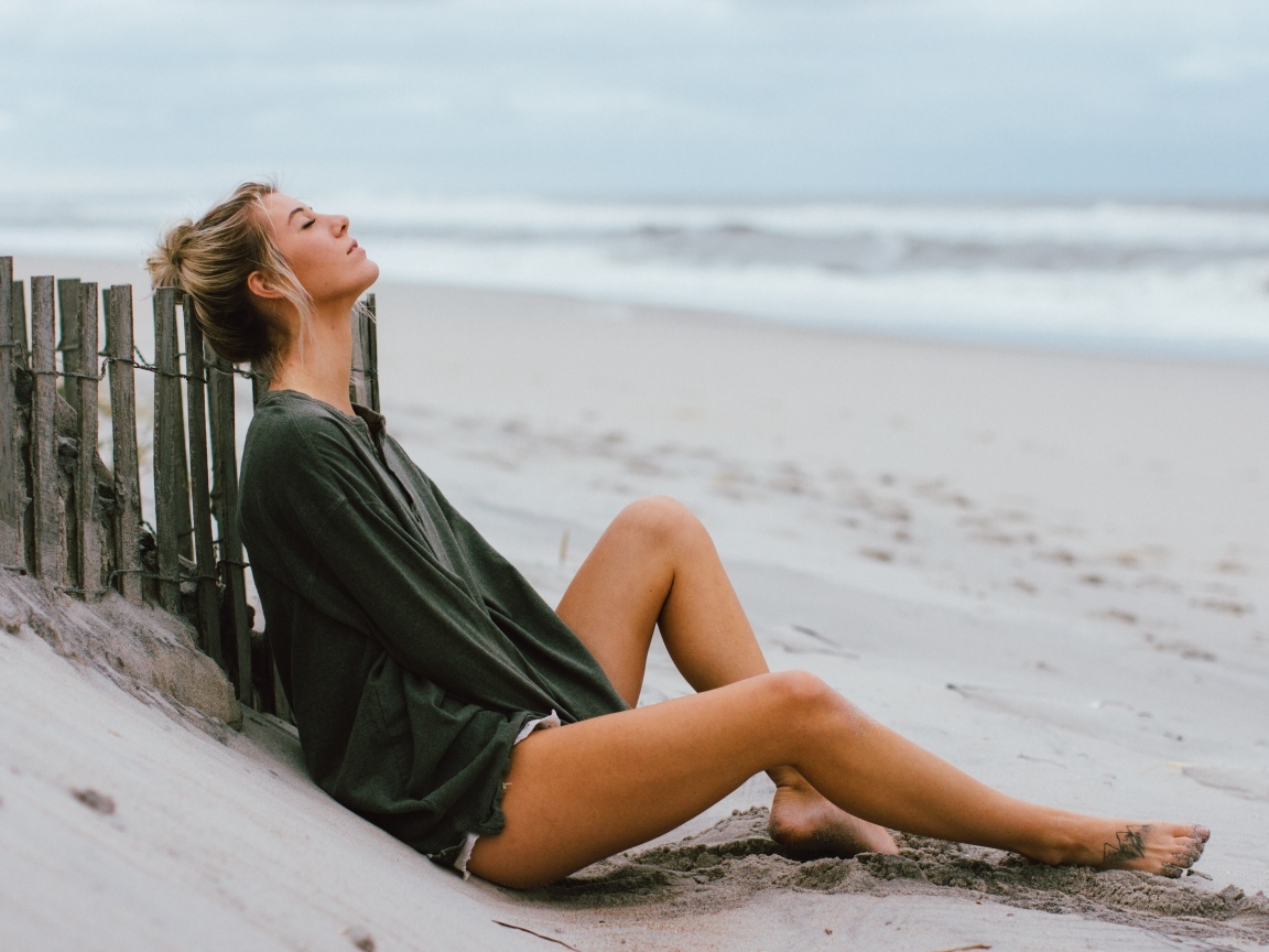 Романтическая девушка лежит на песке у моря