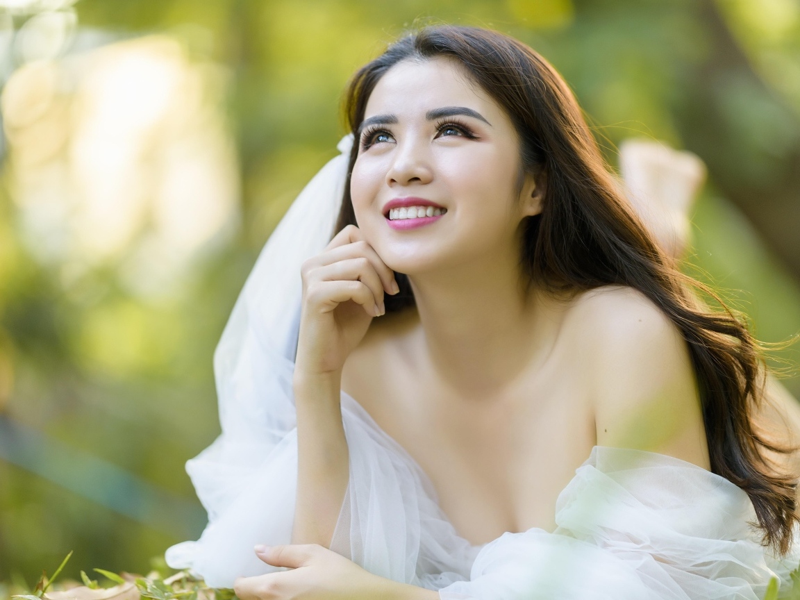 Улыбающаяся девушка азиатка в платье невесты