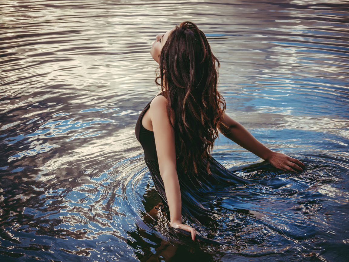 Молодая девушка купается в воде