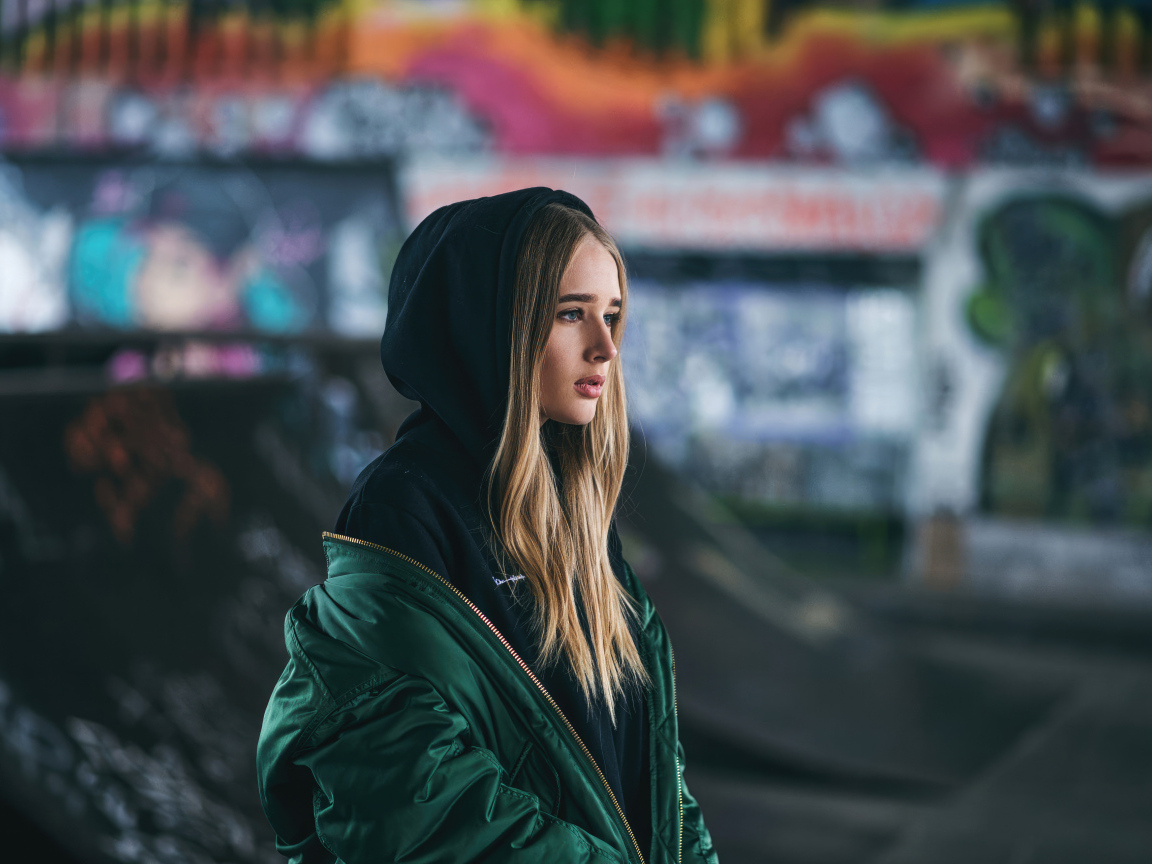 Молодая девушка в зеленой куртке