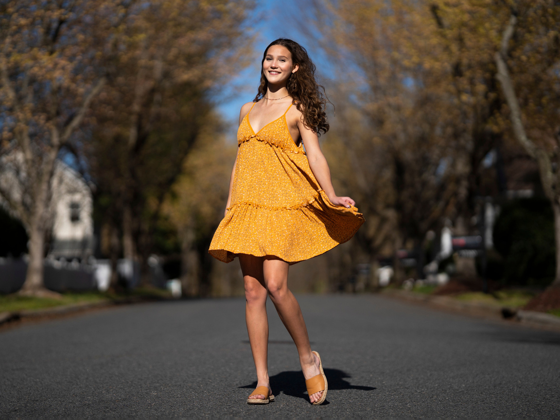 Молодая девушка в коротком платье на дороге  летом