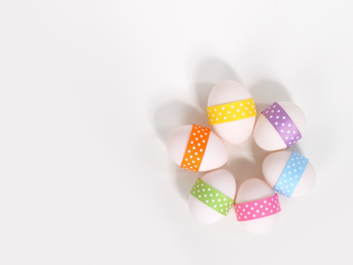 Белые яйца с ленточками на белом фоне
