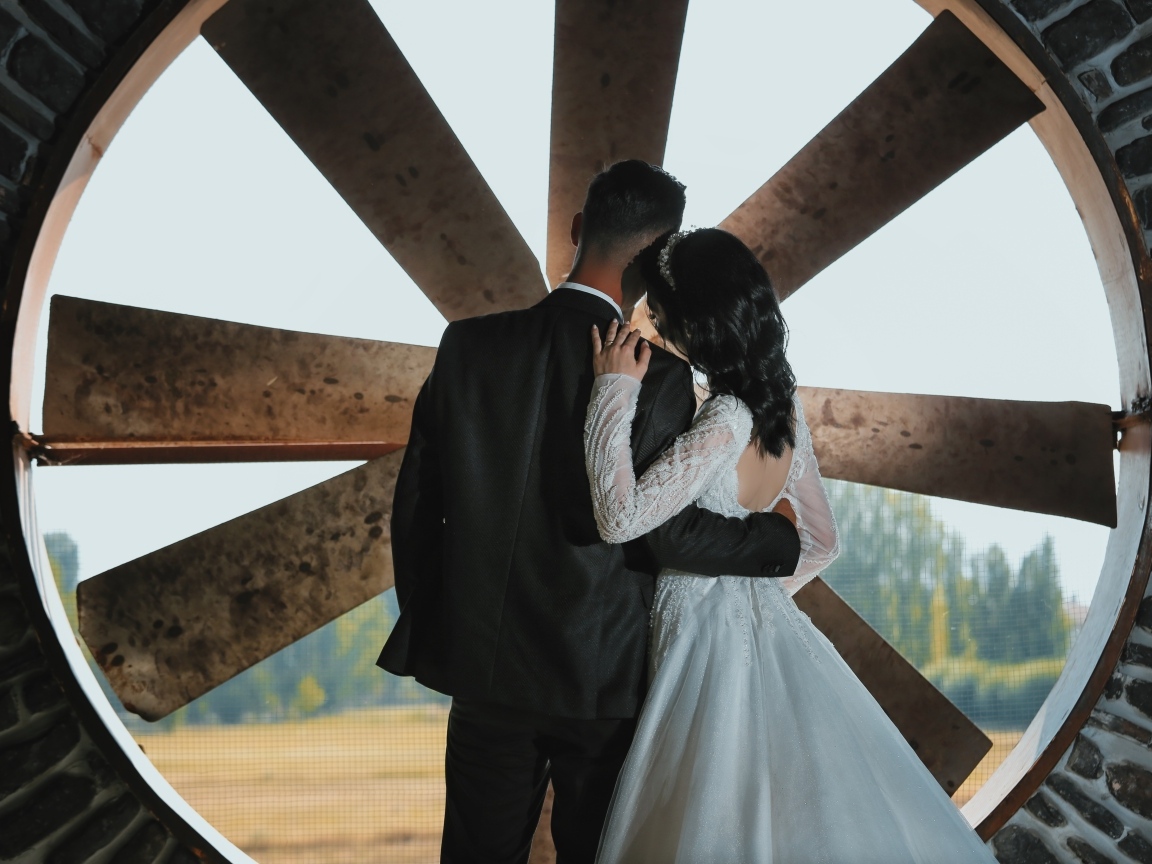 Влюбленные жених и невеста стоят у окна