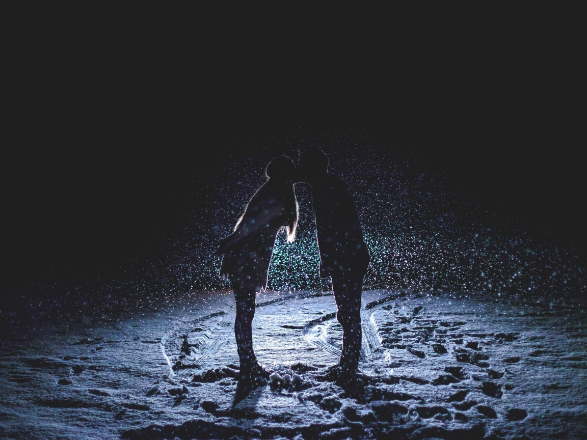 Поцелуй влюбленной пары на снегу ночью