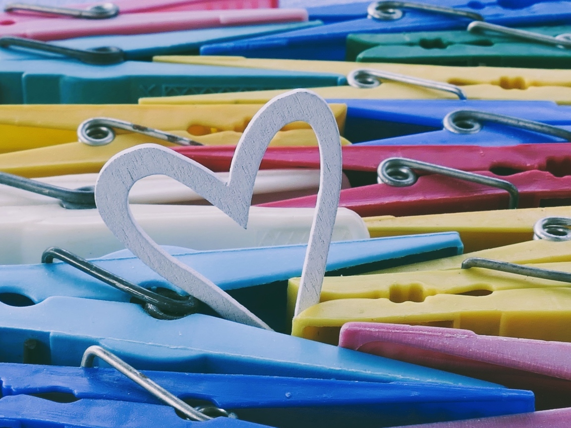Белое деревянное сердце с разноцветными прищепками