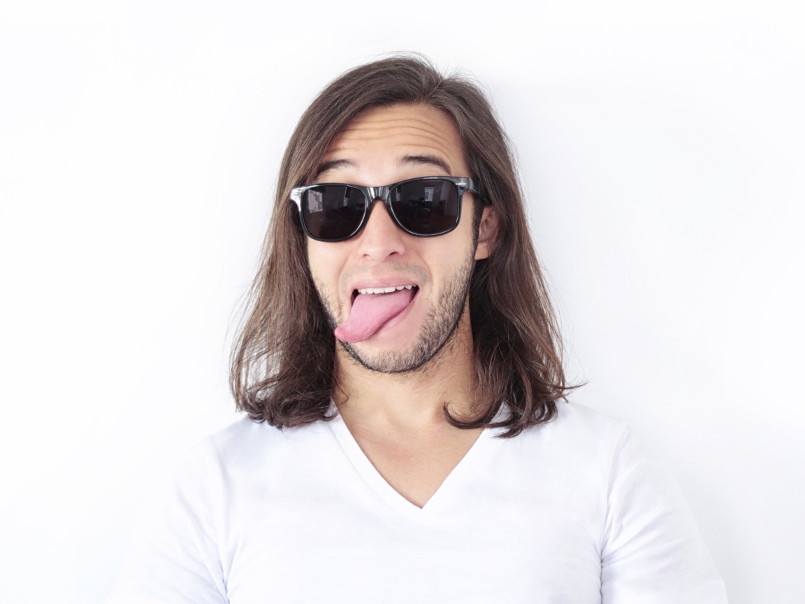 Мужчина в очках с высунутым языком