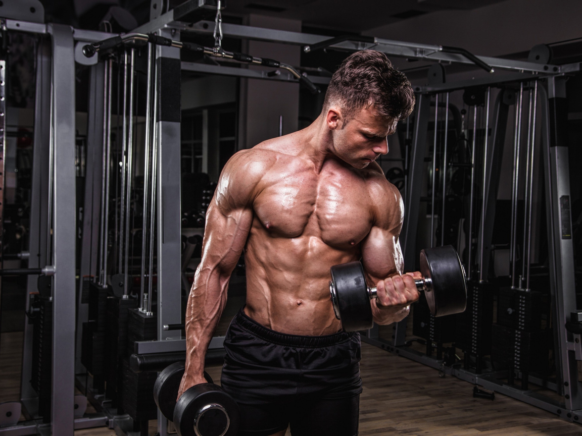 Сильный мужчина качает мускулы 