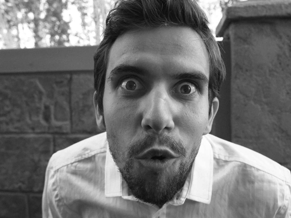 Удивленный взгляд мужчины в белой рубашке