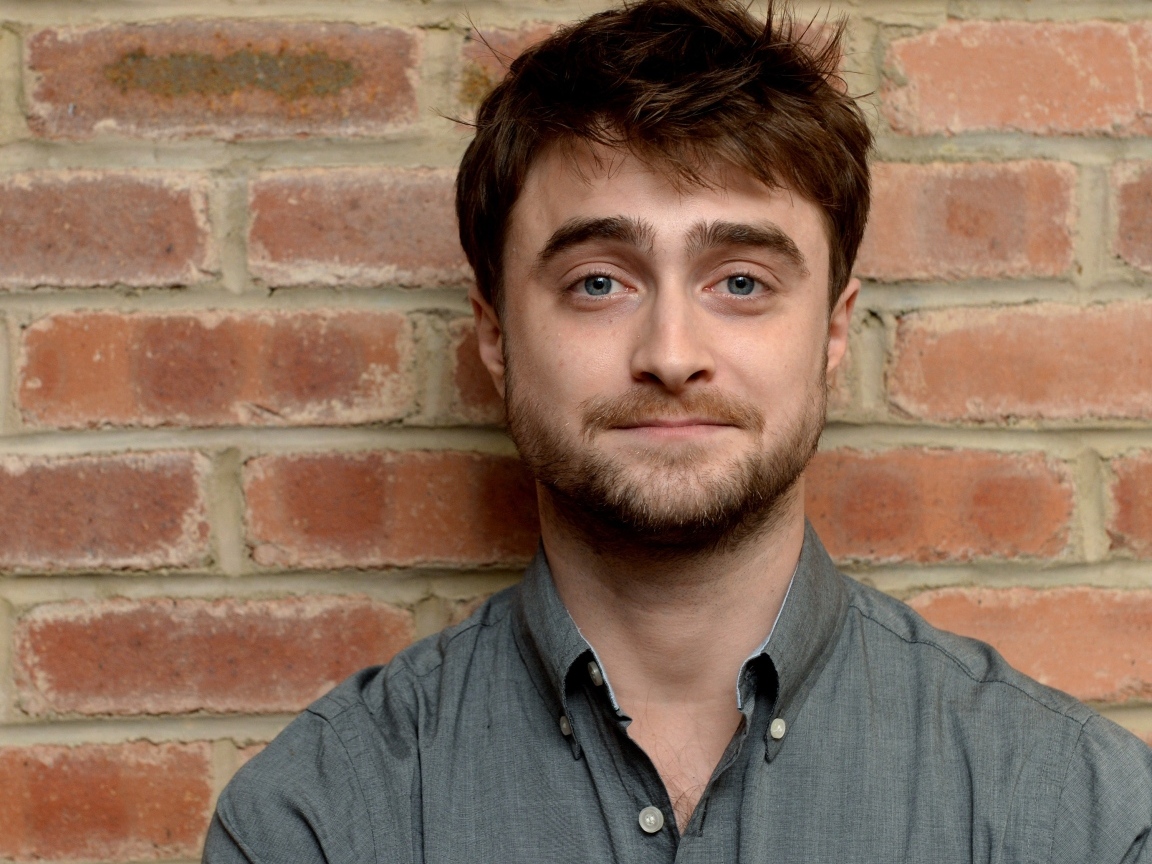 Актер Дэниел Рэдклифф стоит у стены