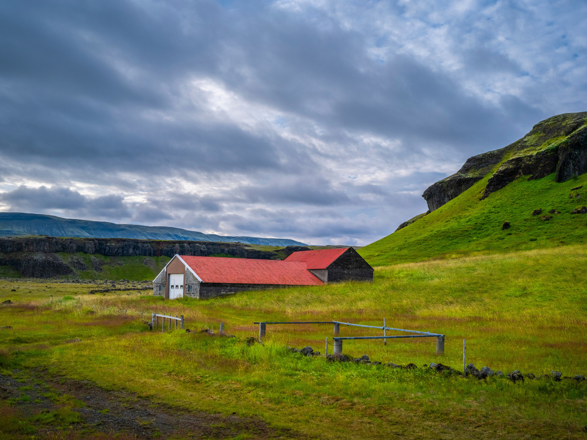Дом у покрытой зеленью поры под грозовым небом