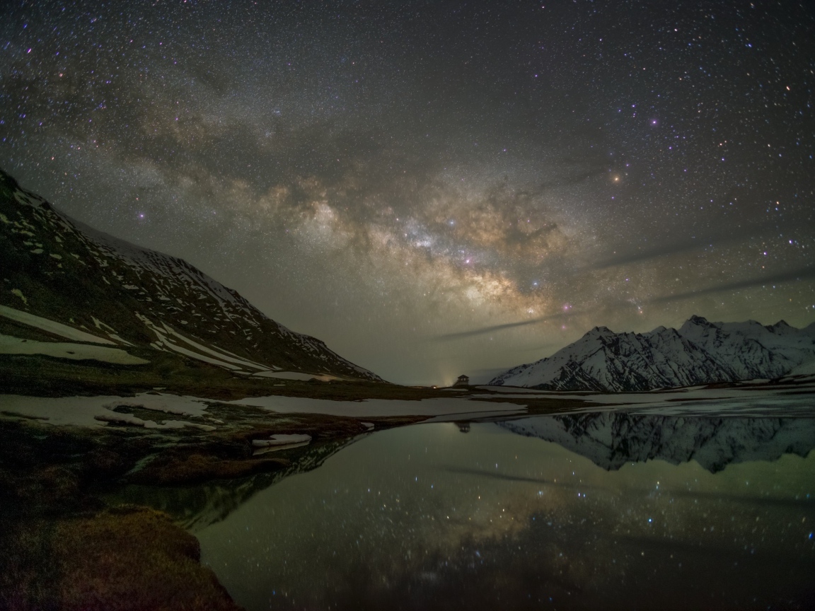 Млечный путь в ночном небе над горным озером зимой