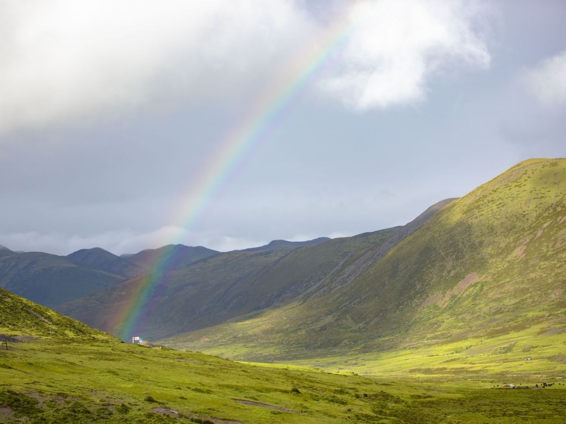 Радуга над покрытыми зеленью холмами
