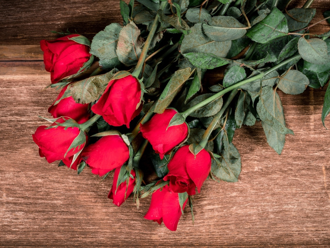 Букет красных английских роз на деревянном столе