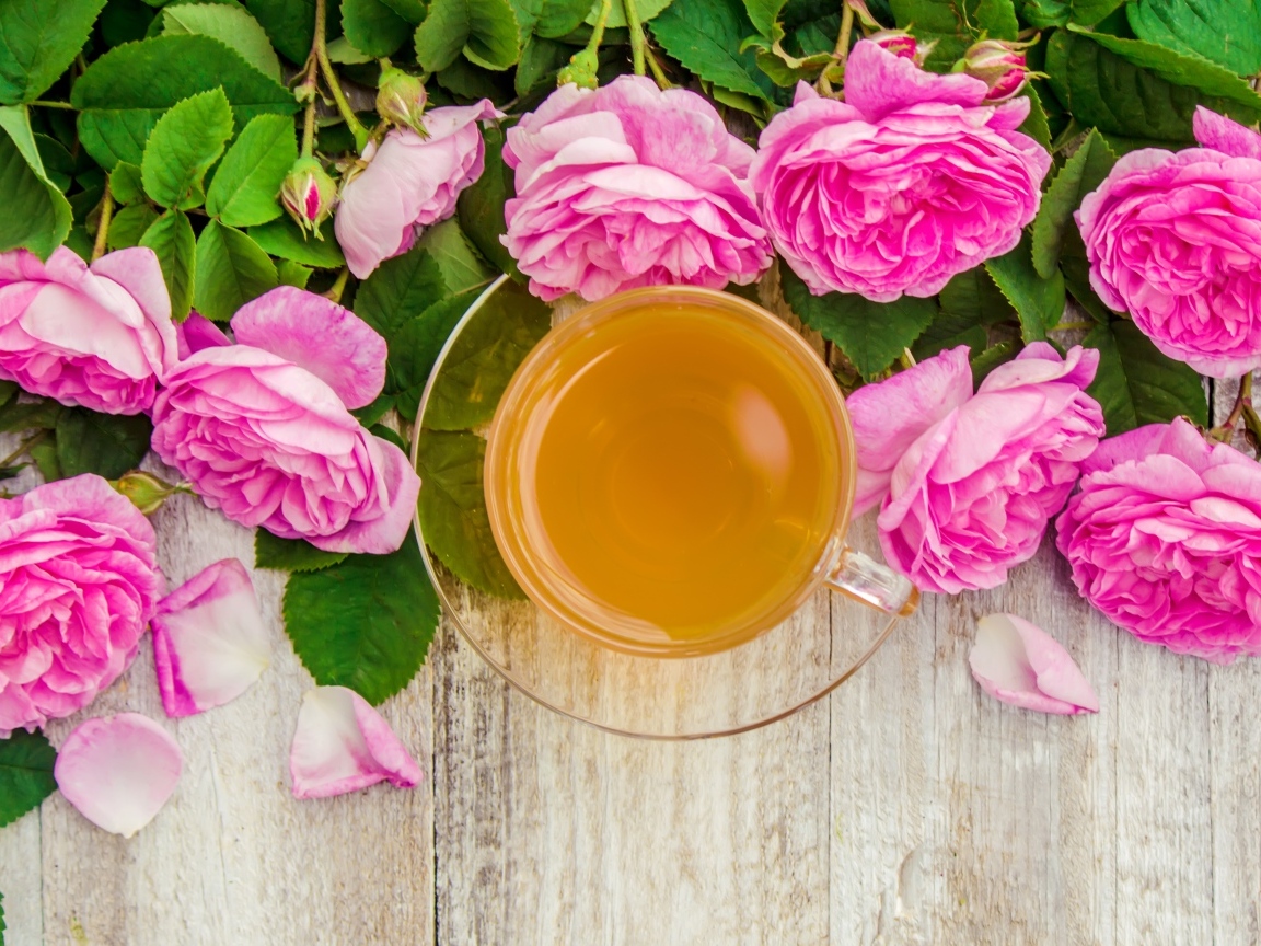 Букет роз с чашкой чая на столе