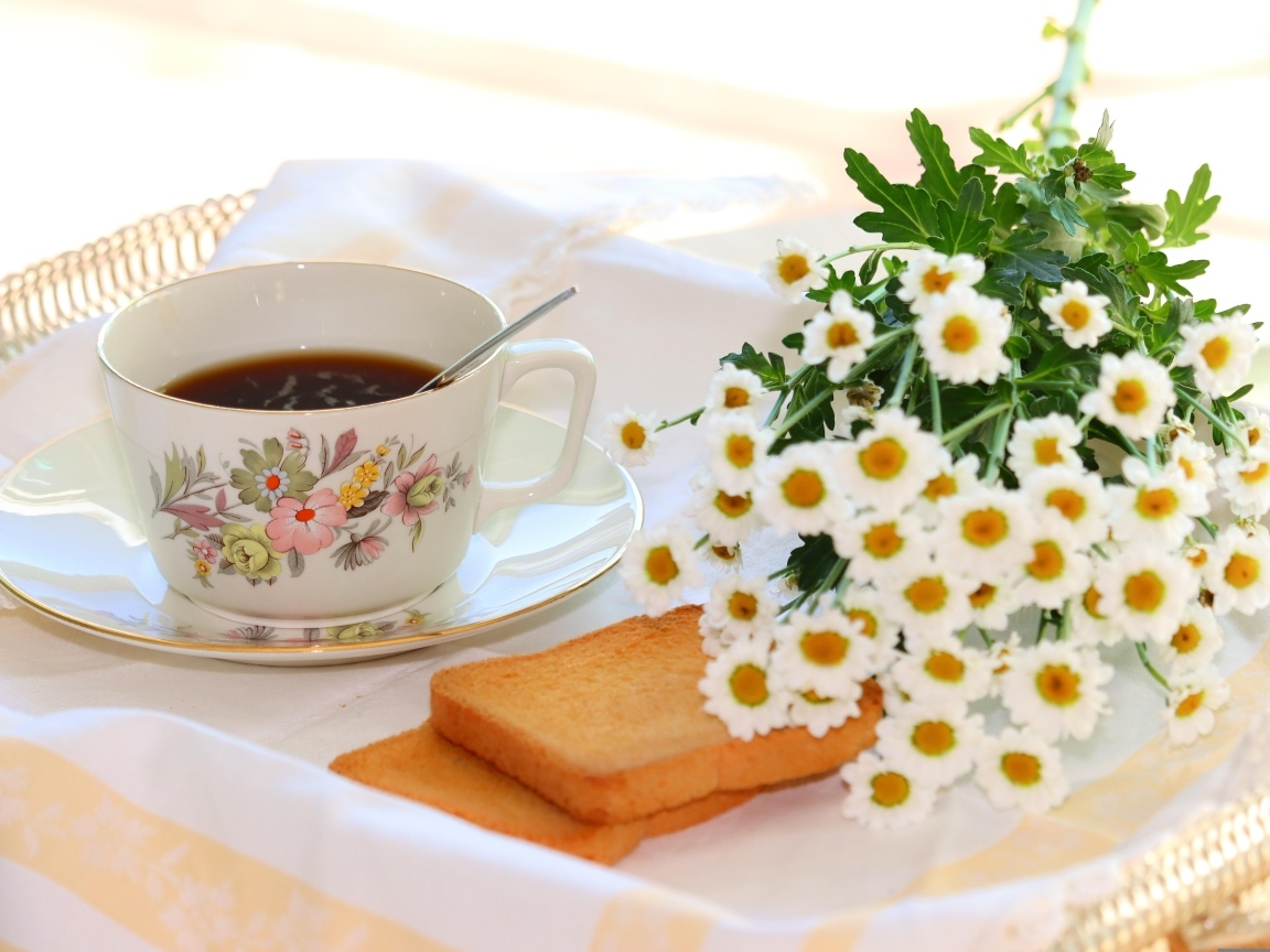 Букет белых ромашек с чашкой чая  и хлебом