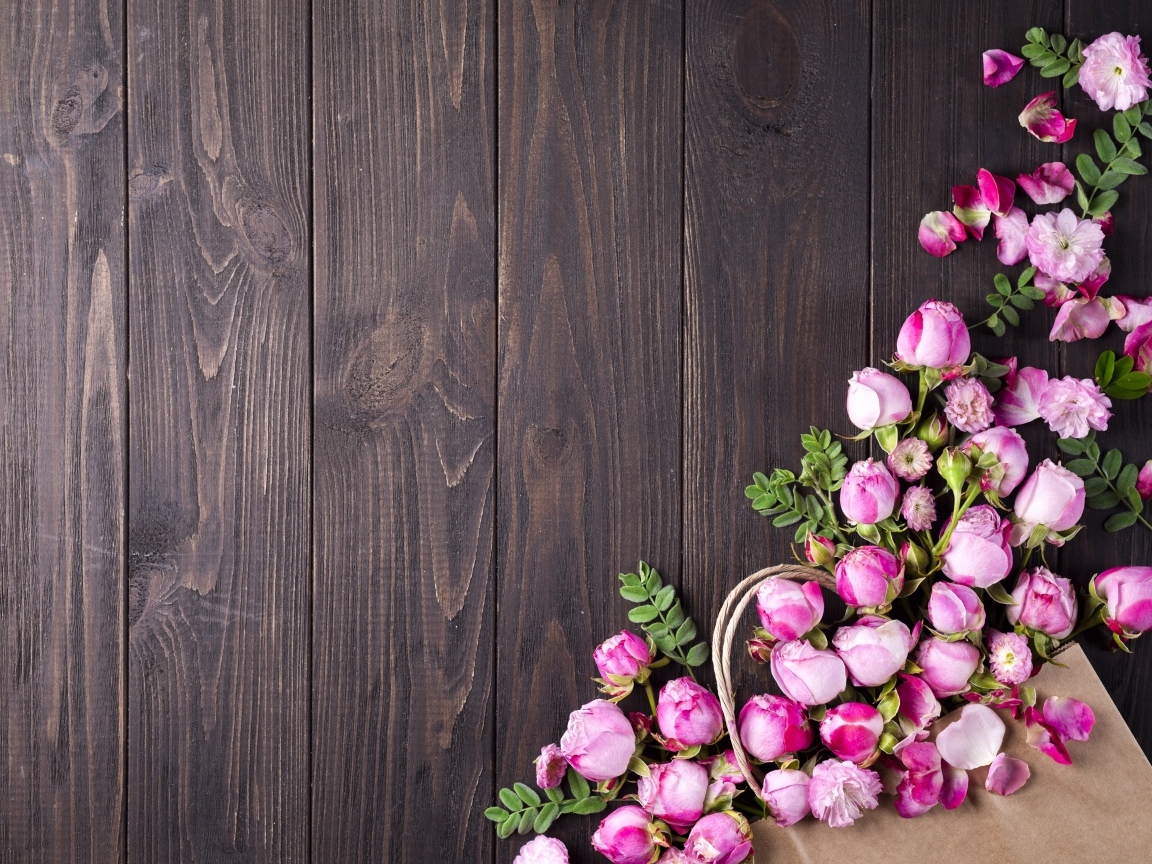 Бутоны розовой розы на деревянном столе