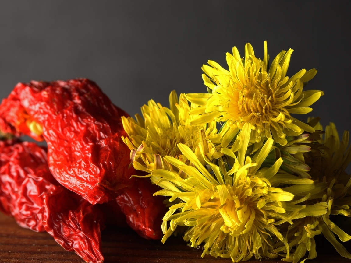 Желтые одуванчики с красным перцем на столе