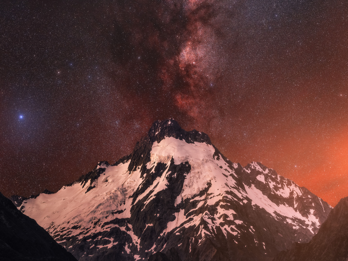 Заснеженная вершина горы под звездным небом