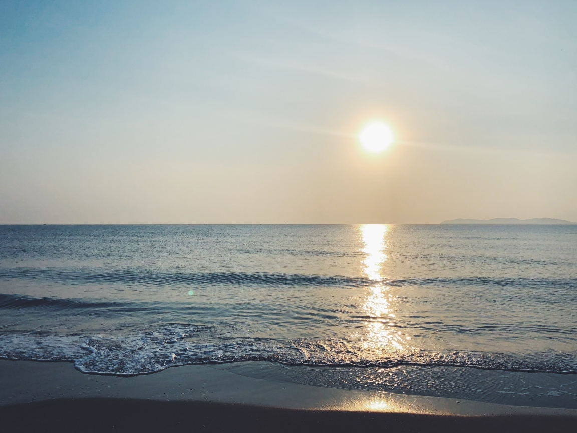 Яркое солнце над спокойным морем летом