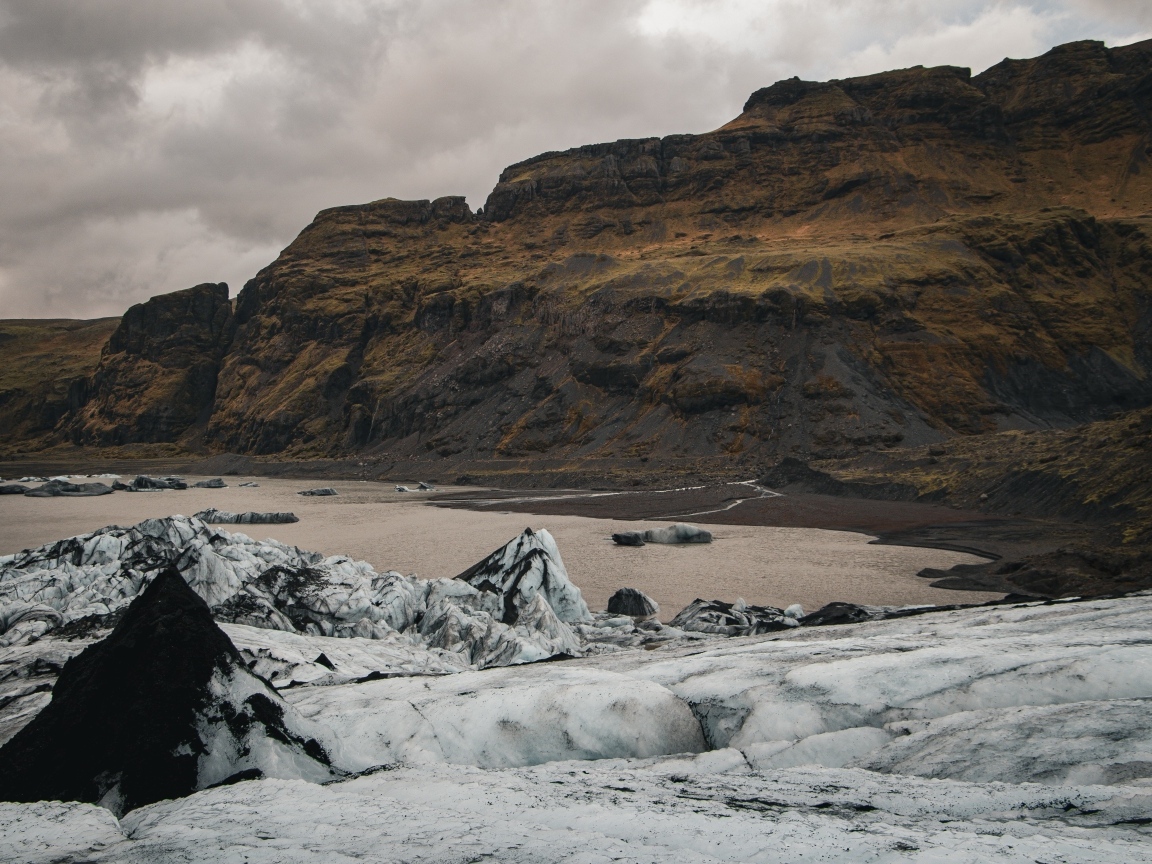 Холодный грязный снег на берегу моря у гор 