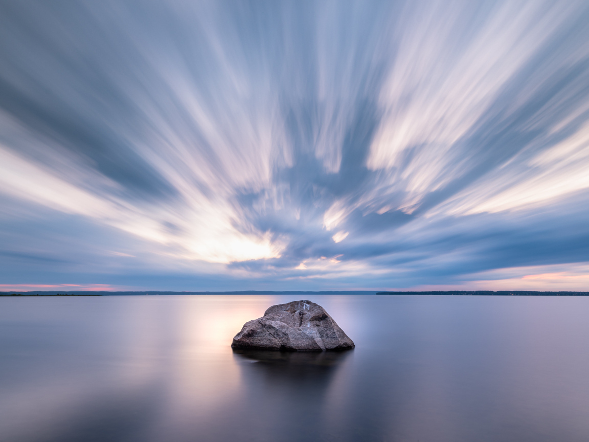 Large stone in the water under a beautiful sky