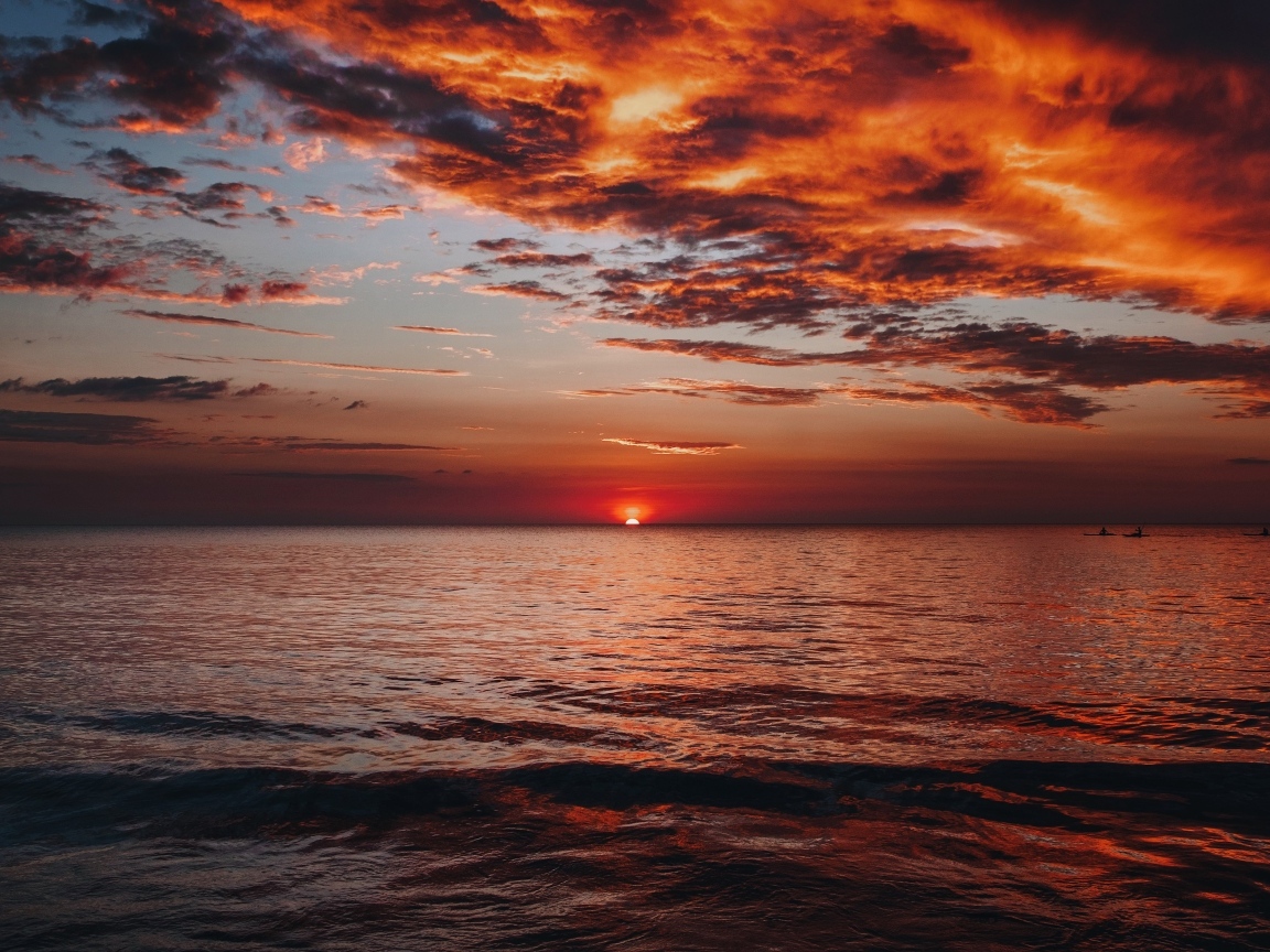 Красные облака в небе над морем на закате