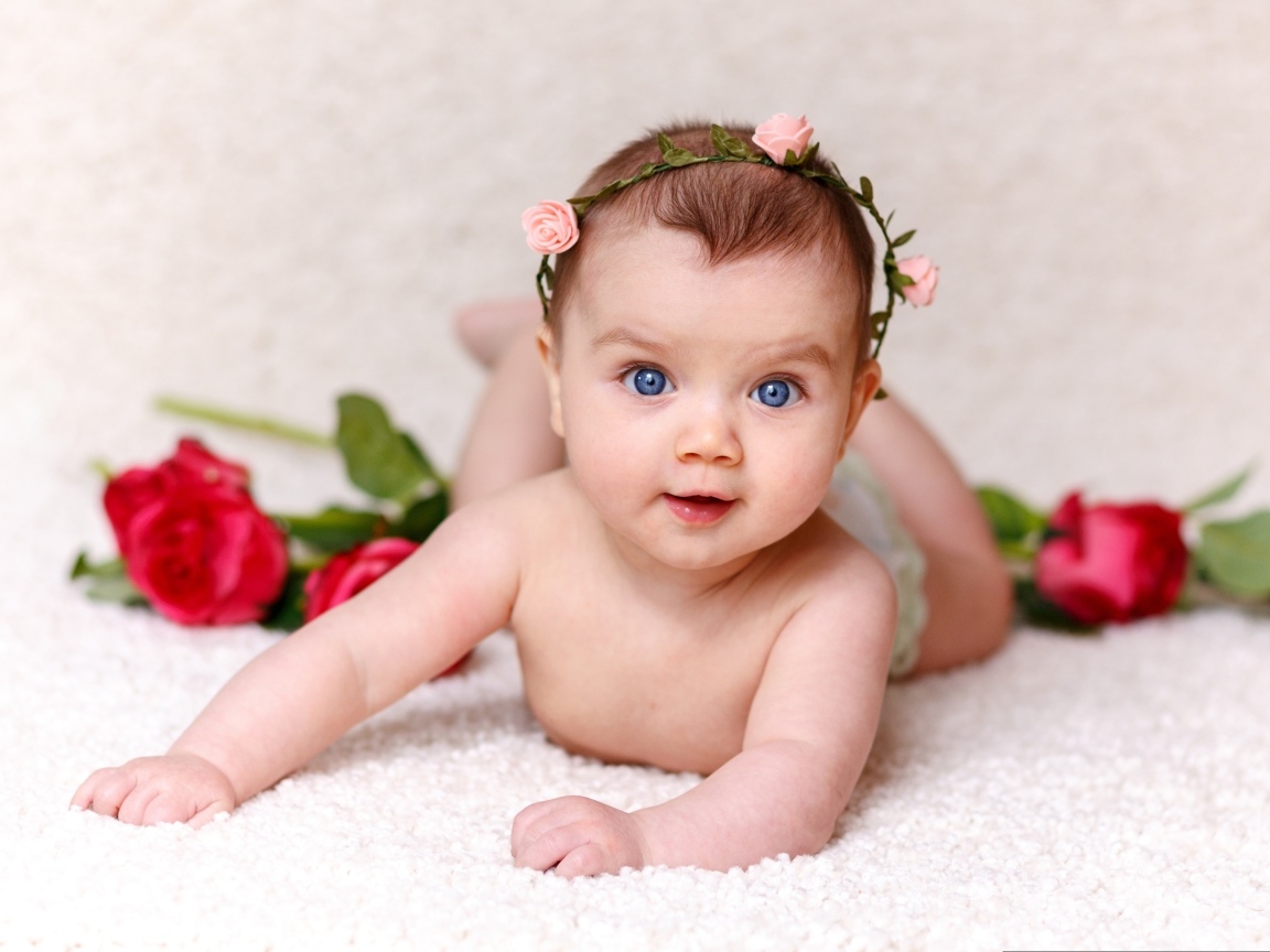 Милая голубоглазая малышка с цветами роз