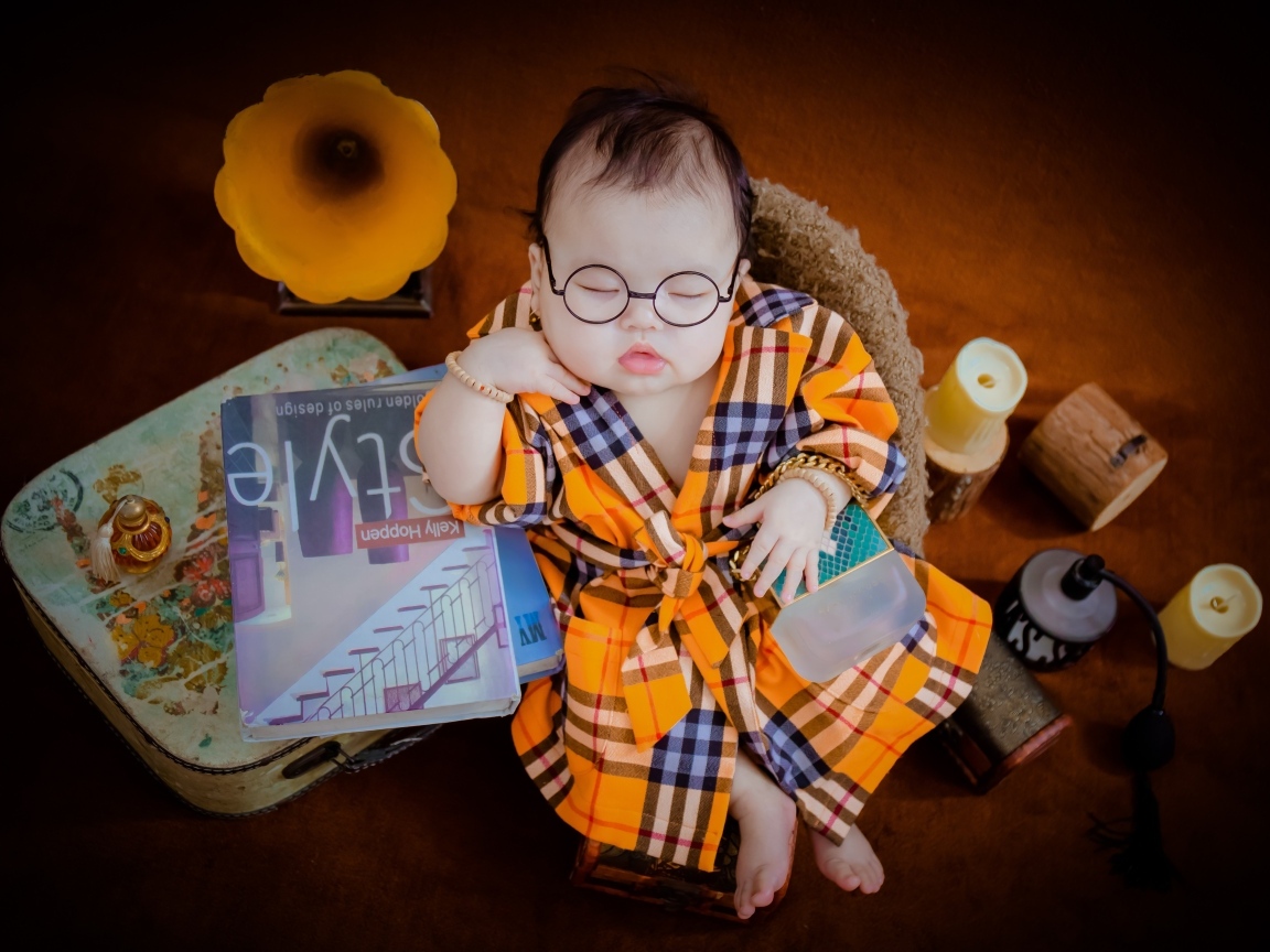 Маленький спящий ребенок в очках и халате