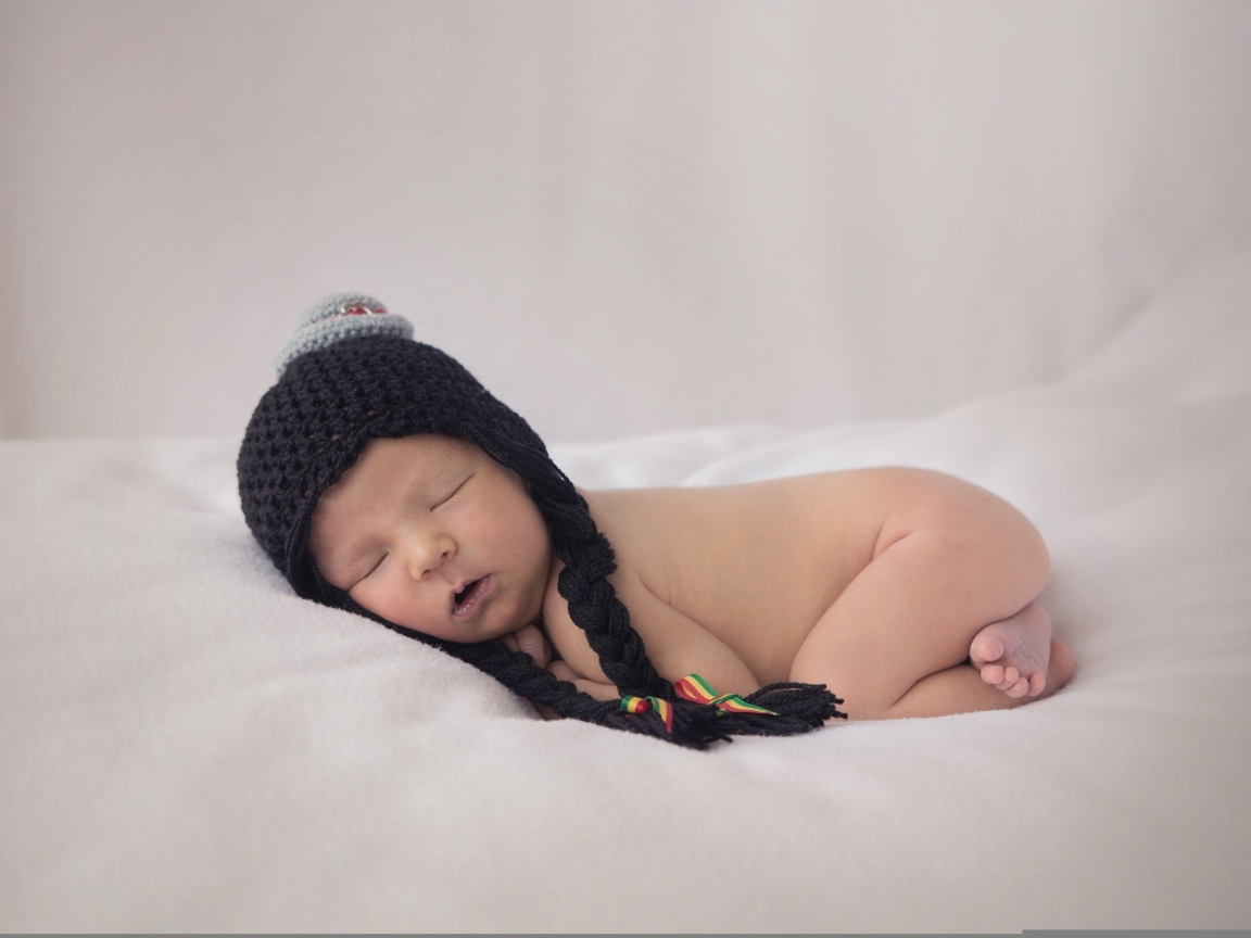 Новорожденная кроха в черной шапке