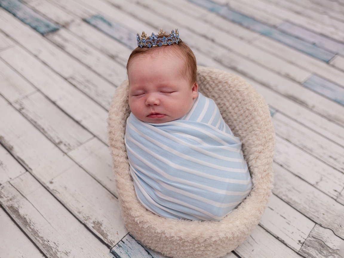 Новорожденный ребенок с короной на голове