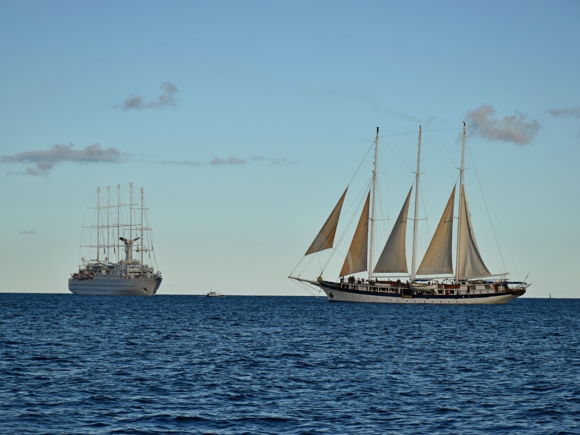 Парусная яхта и корабль в открытом море