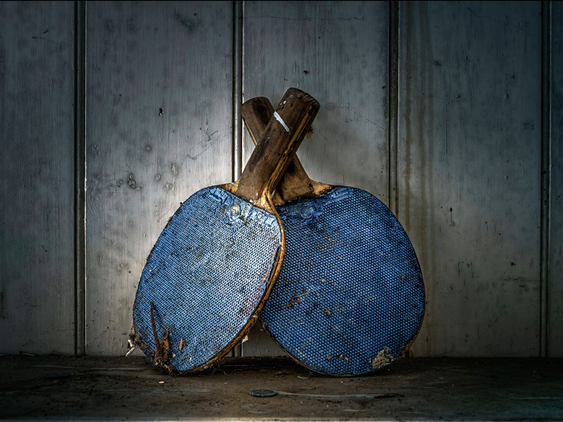 Две старые ракетки для настольного тенниса у стены