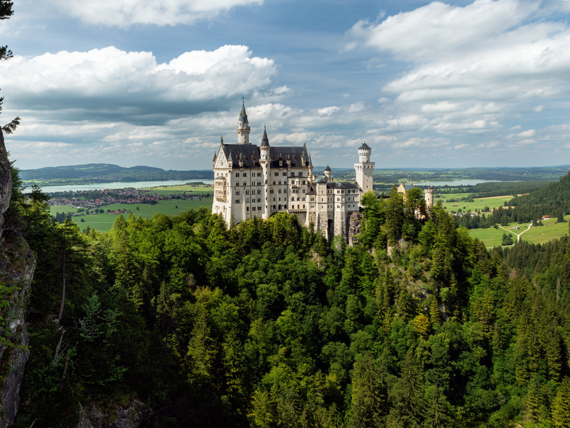 Замок Нойшванштайн в густых зарослях деревьев, Германия