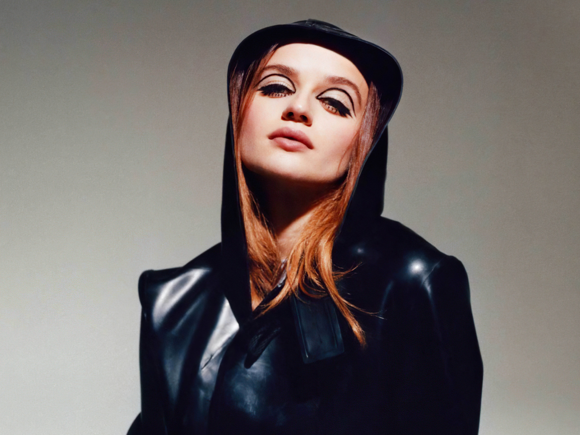 Актриса Джоуи Кинг в черной куртке на сером фоне