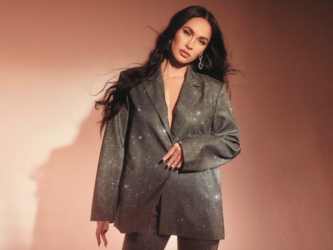 Актриса Меган Фокс в ярком костюме у стены