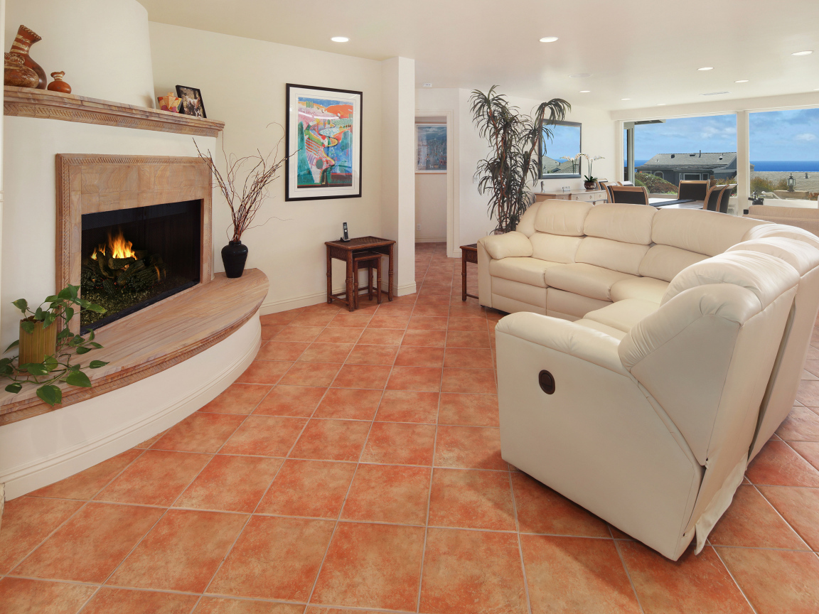 Красивый белый кожаный диван в гостиной с камином