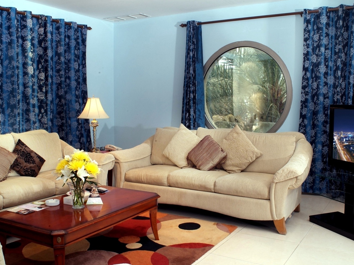 Синие шторы в гостиной с двумя диванами