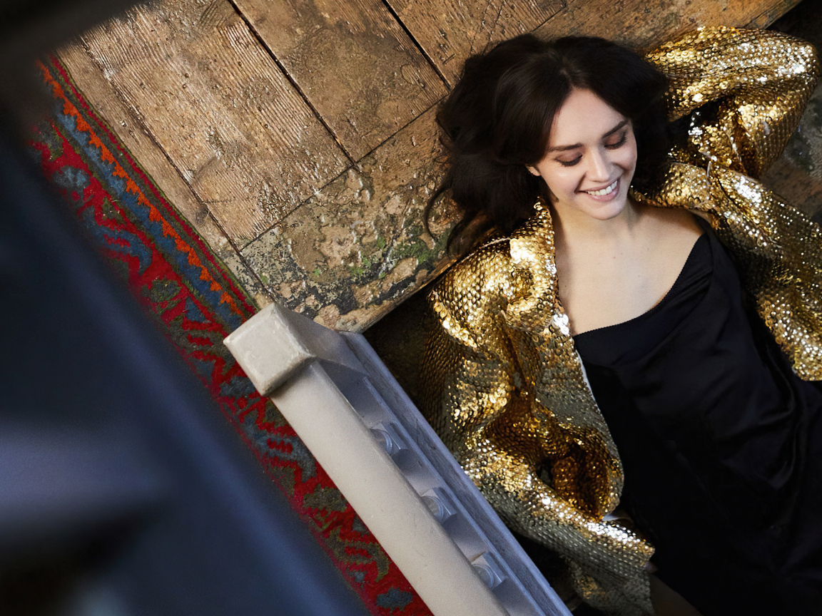 Улыбающаяся актриса Оливия Кук в черном платье