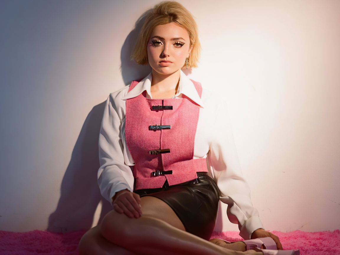 Молодая девушка Пейтон Рой Лист сидит у стены