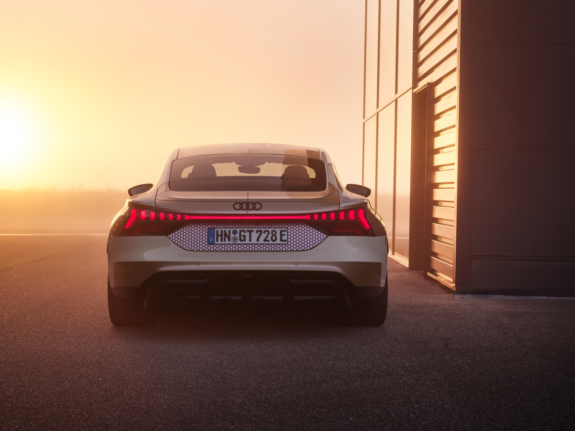 Вид сзади на автомобиль Audi RS E-Tron GT Prototype на фоне солнца