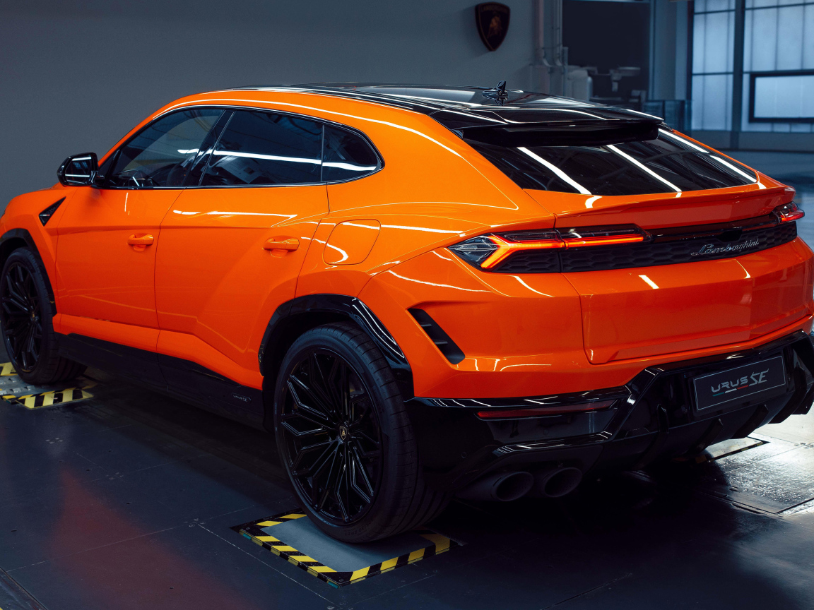 Вид сзади на оранжевый автомобиль  Lamborghini Urus SE Plug-In Hybrid 2024 года