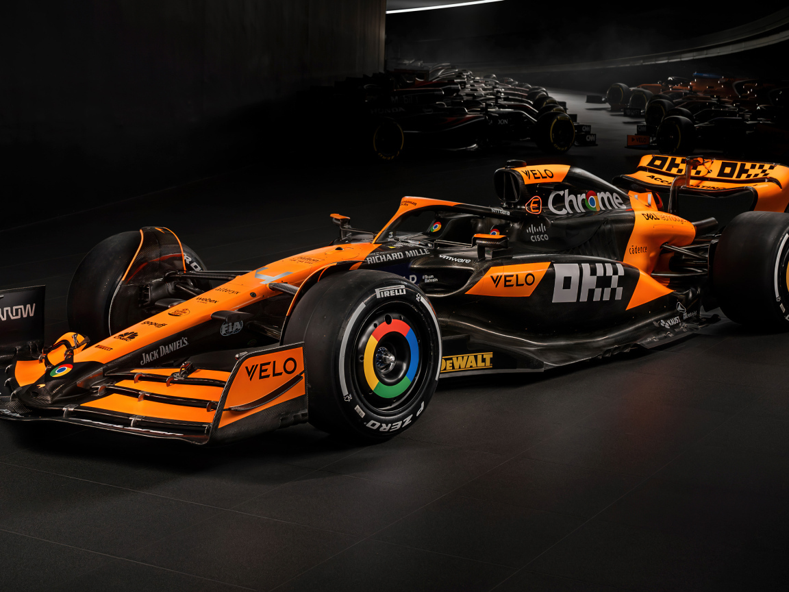 Гоночный автомобиль McLaren MCL38 Formula 1 2024 года на черном фоне