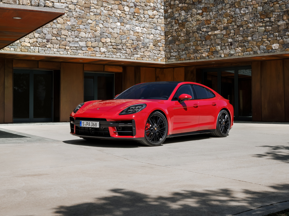 Красный автомобиль Porsche Panamera GTS 2024 года у здания