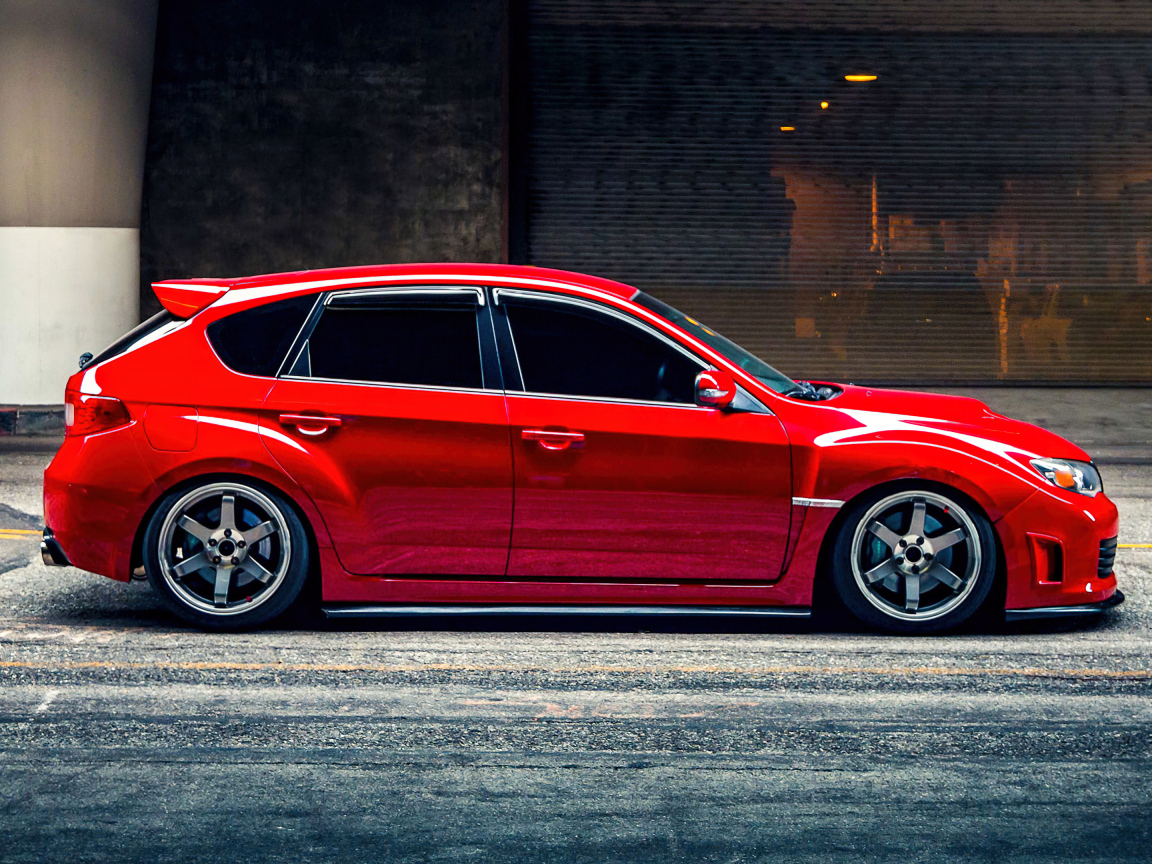 Красный автомобиль Subaru Impreza WRX STI вид сбоку